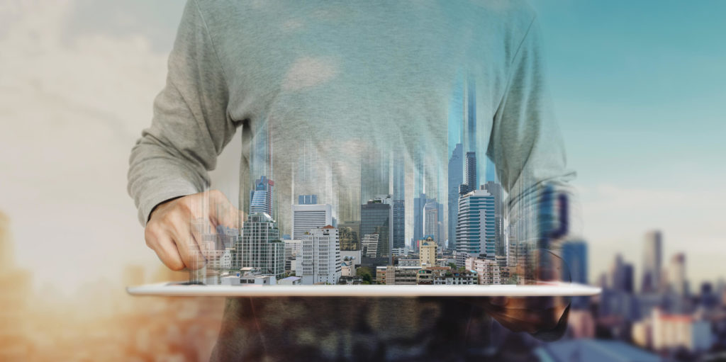 A imagem mostra um homem segurando um holograma com vários prédios. Foto para ilustrar o texto sobre o futuro das imobiliárias